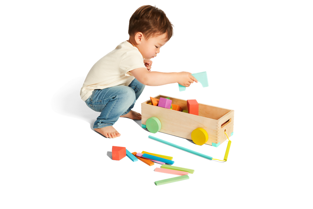 Child putting blocks into the wooden box from The Block Set by Lovevery